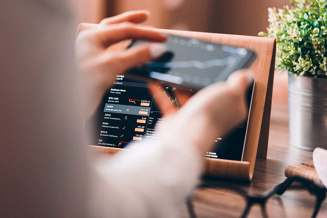 Woman Analyzing Stock Charts via Smartphone at Home