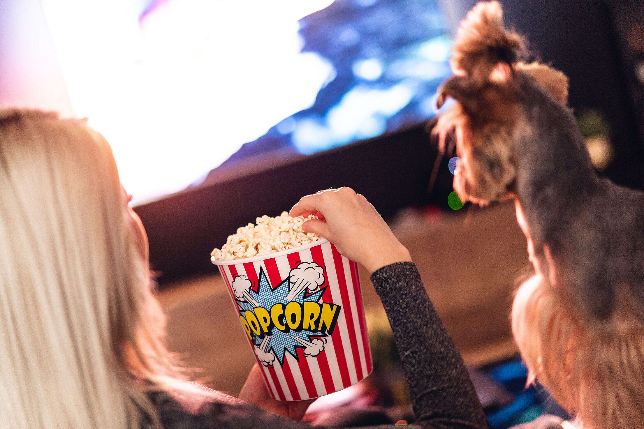 Woman and Her Dog are Watching a Movie and Eating Popcorn Free Stock Photo