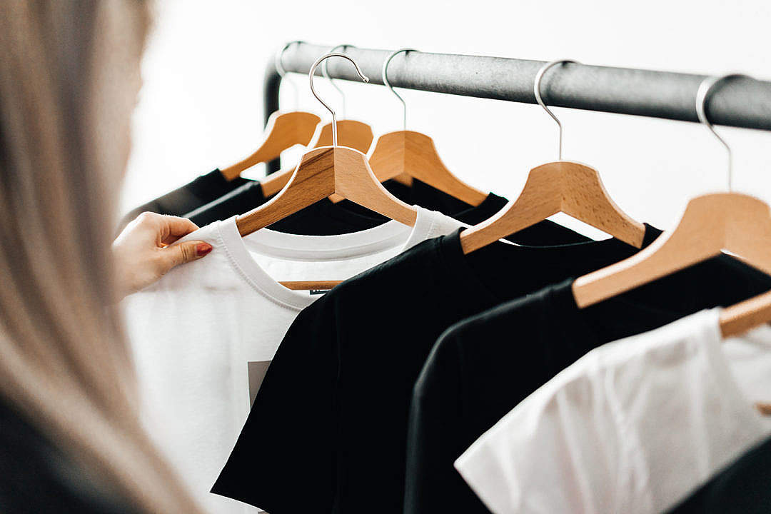 Download Woman Choosing T-Shirts During Clothing Shopping at Apparel Store FREE Stock Photo