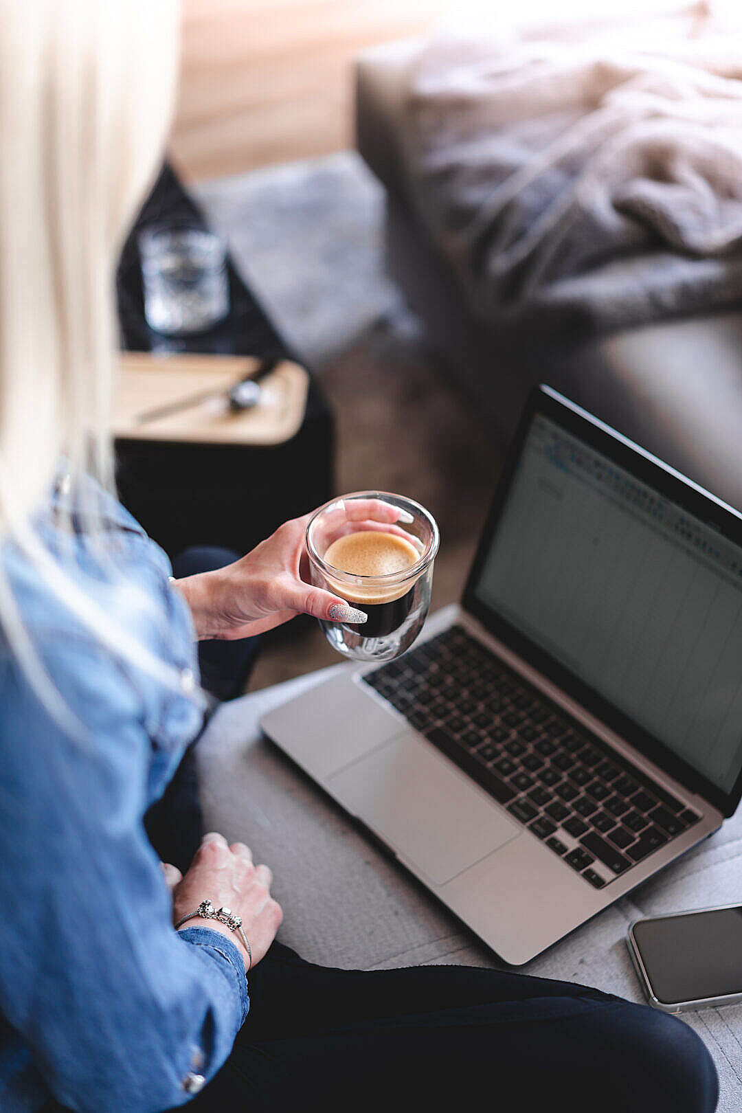 Download Woman Drinking Coffee and Working Remotely on Laptop at Home FREE Stock Photo