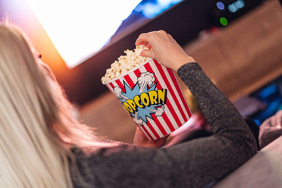 Download Woman Eating Popcorn while Watching a Movie FREE Stock Photo