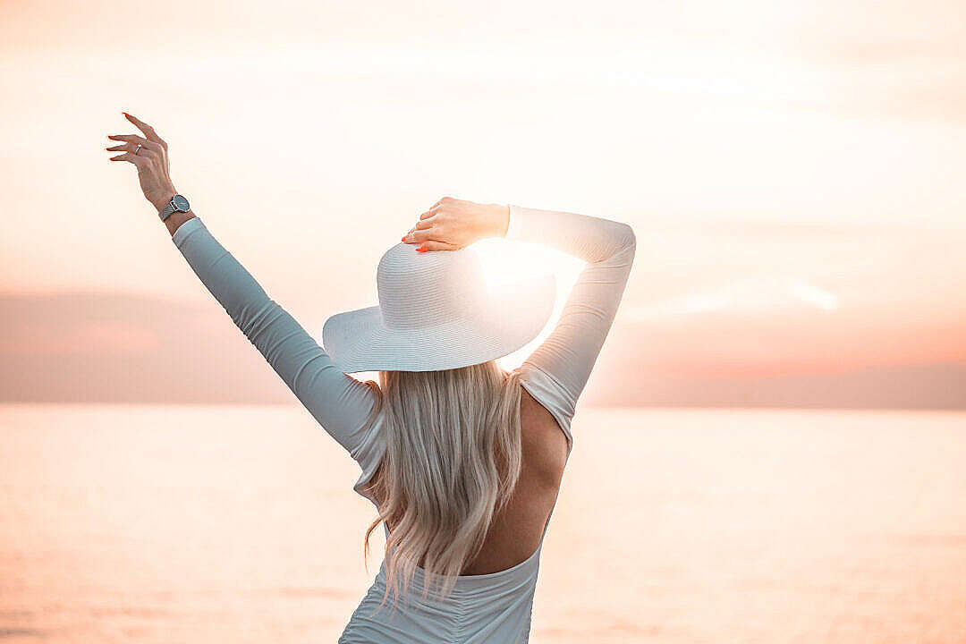 Woman Enjoying the Sunset by the Sea