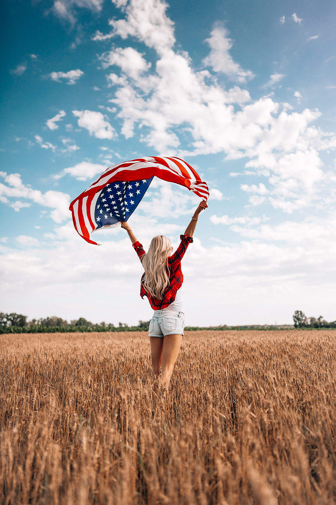 Woman Holding an American Flag in a Field