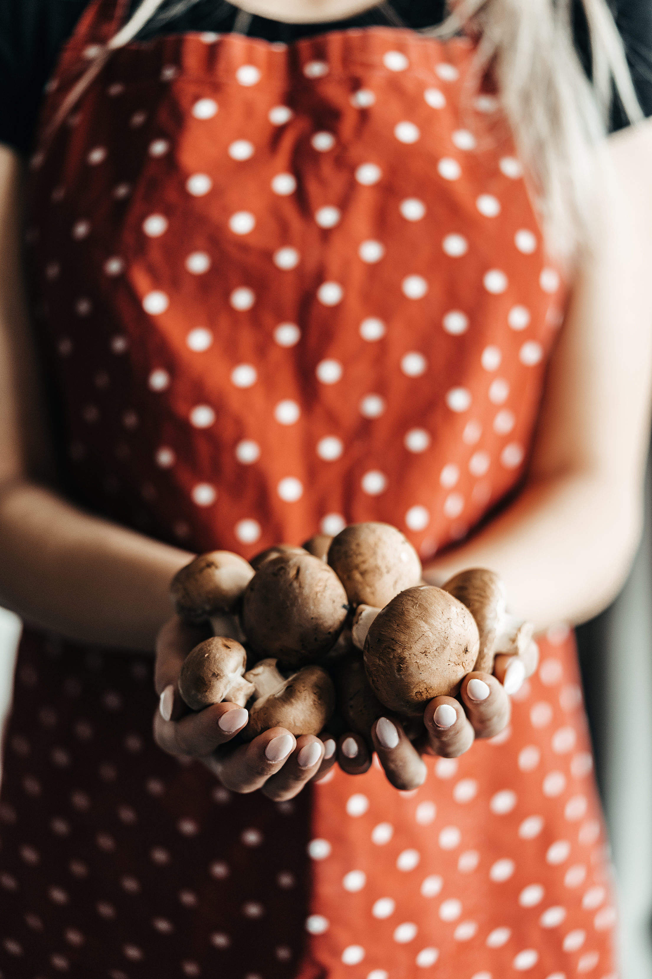 Woman Holding Fresh Mushrooms in the Kitchen Free Stock Photo