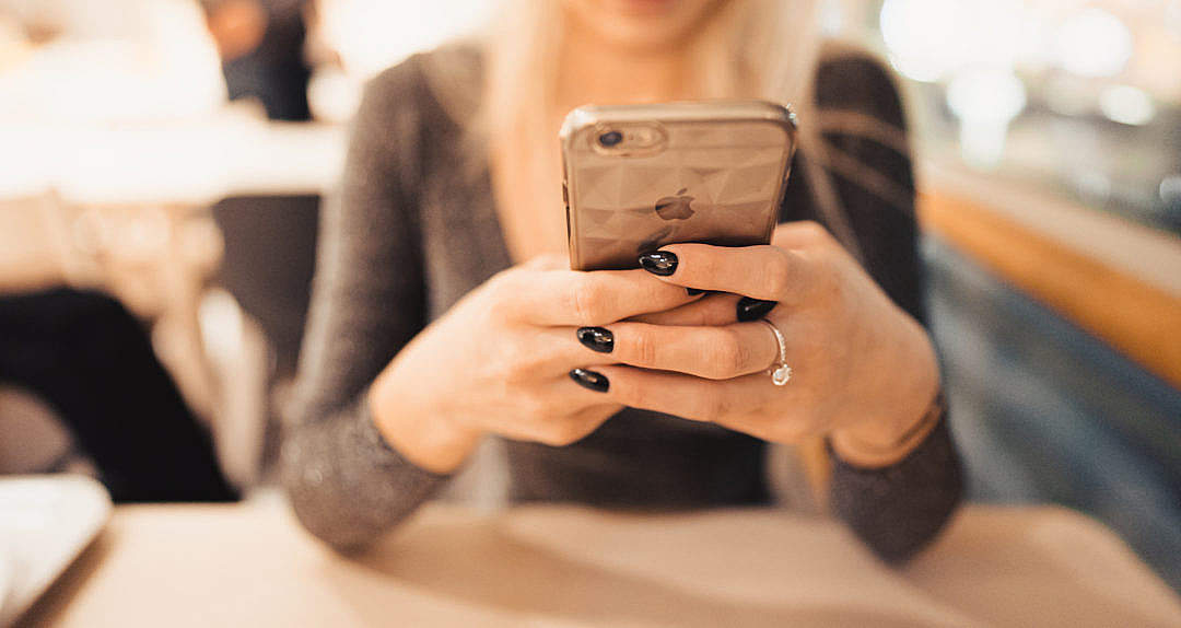 Woman Holding iPhone in Her Hands