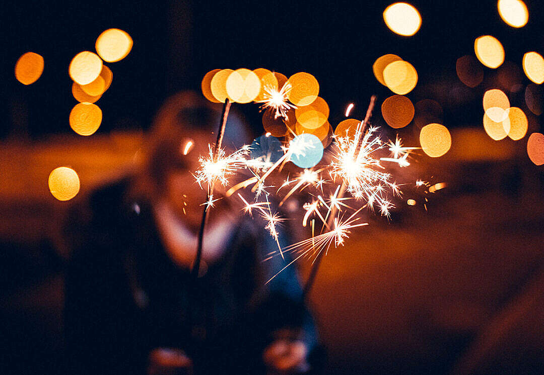 Woman Holding Sparklers in Hands