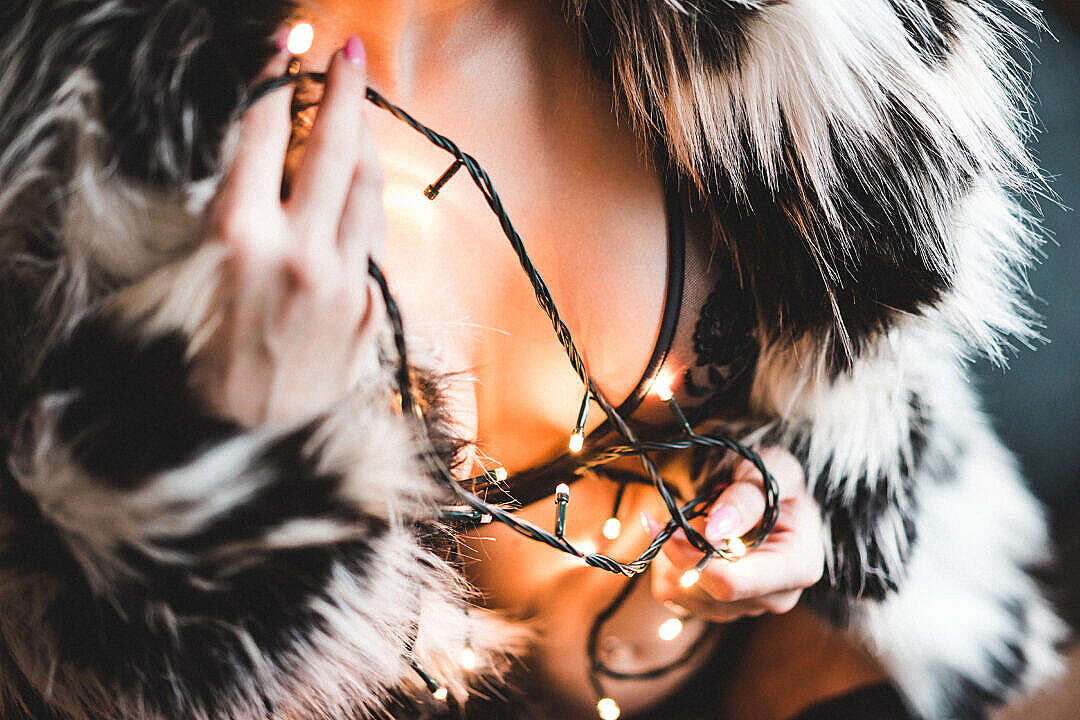 Woman in a Luxury Fur Coat with Christmas Lights