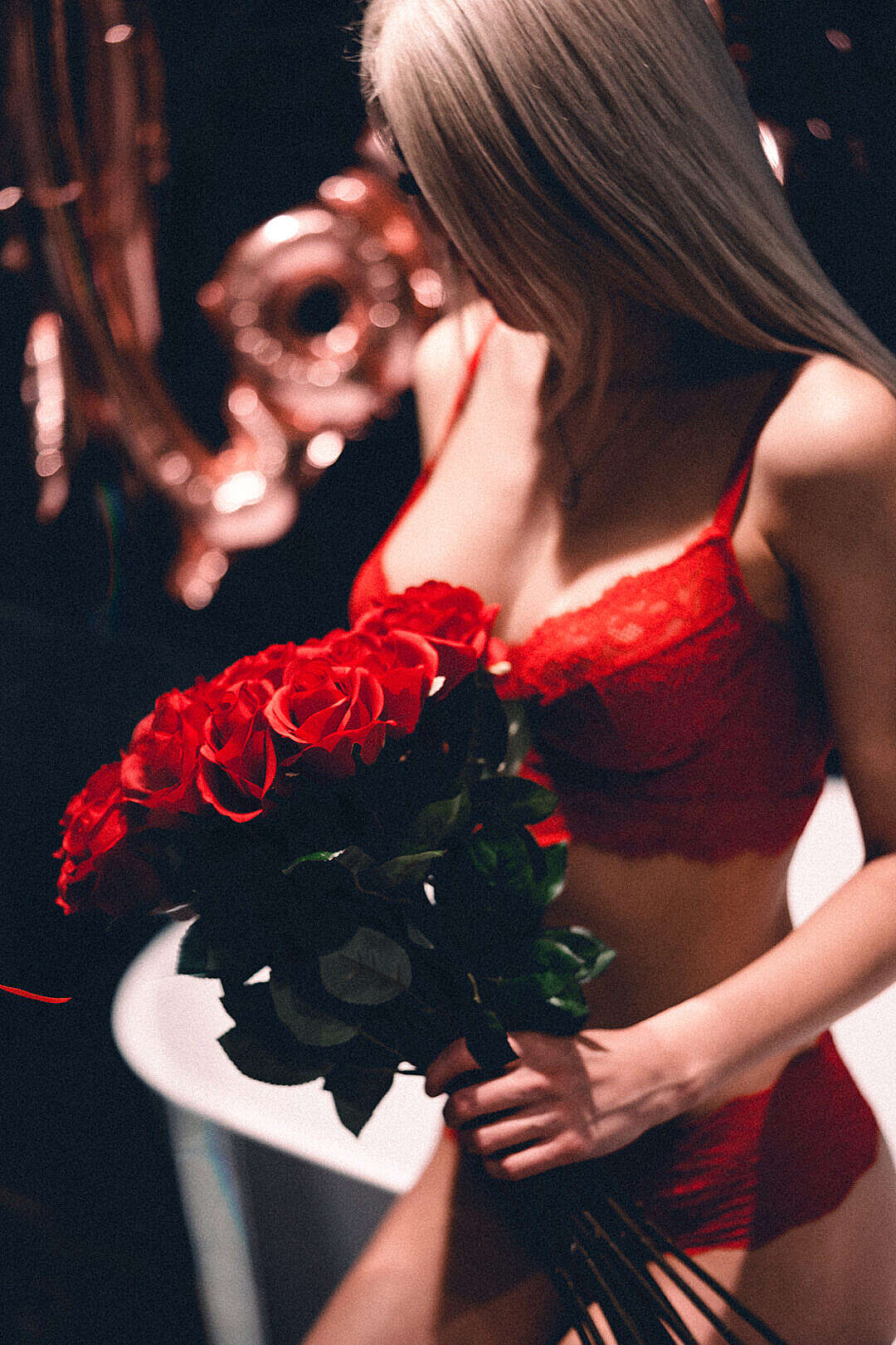 Woman in Red Lace Lingerie Holding a Bouquet of Roses