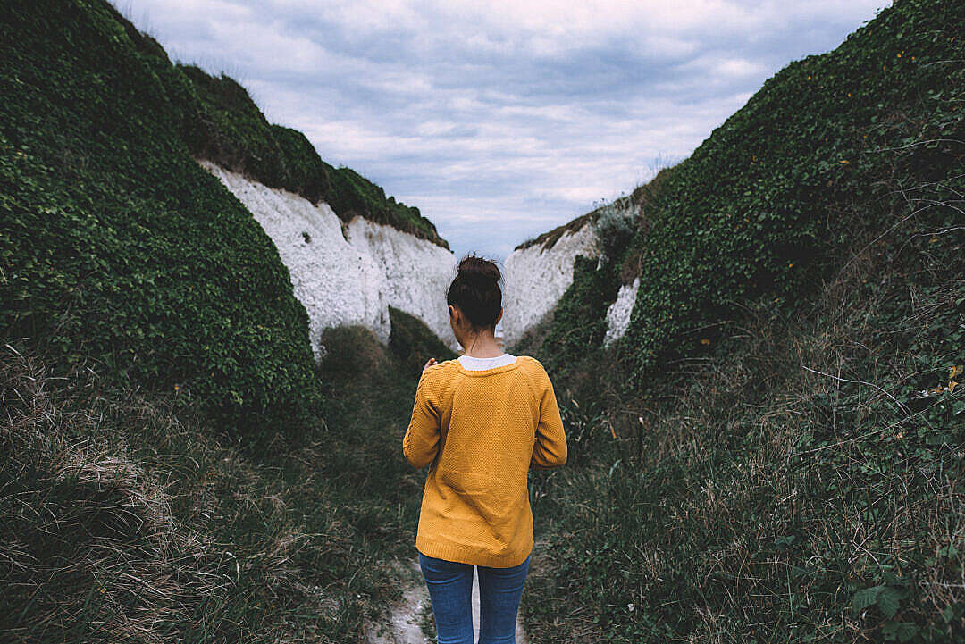 Woman in Yellow Mustard Sweater Between Hills