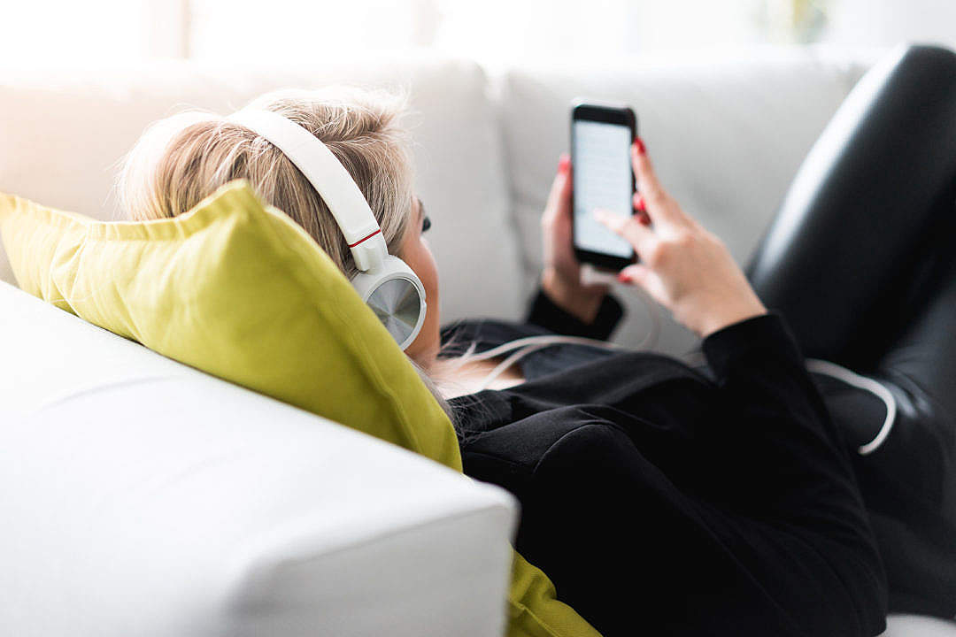 Download Woman Listening to Music on a Sofa FREE Stock Photo
