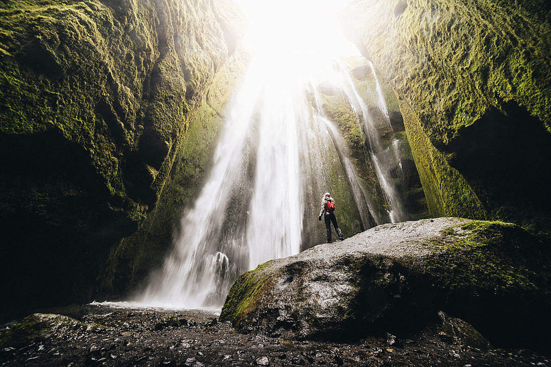 Download Woman Looking Up at Gljúfrabúi Waterfall FREE Stock Photo