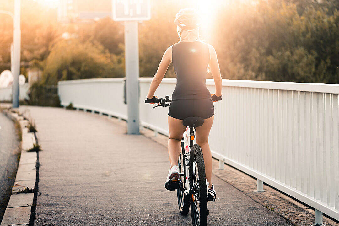 Download Woman Riding a Bike During Evening Sun FREE Stock Photo
