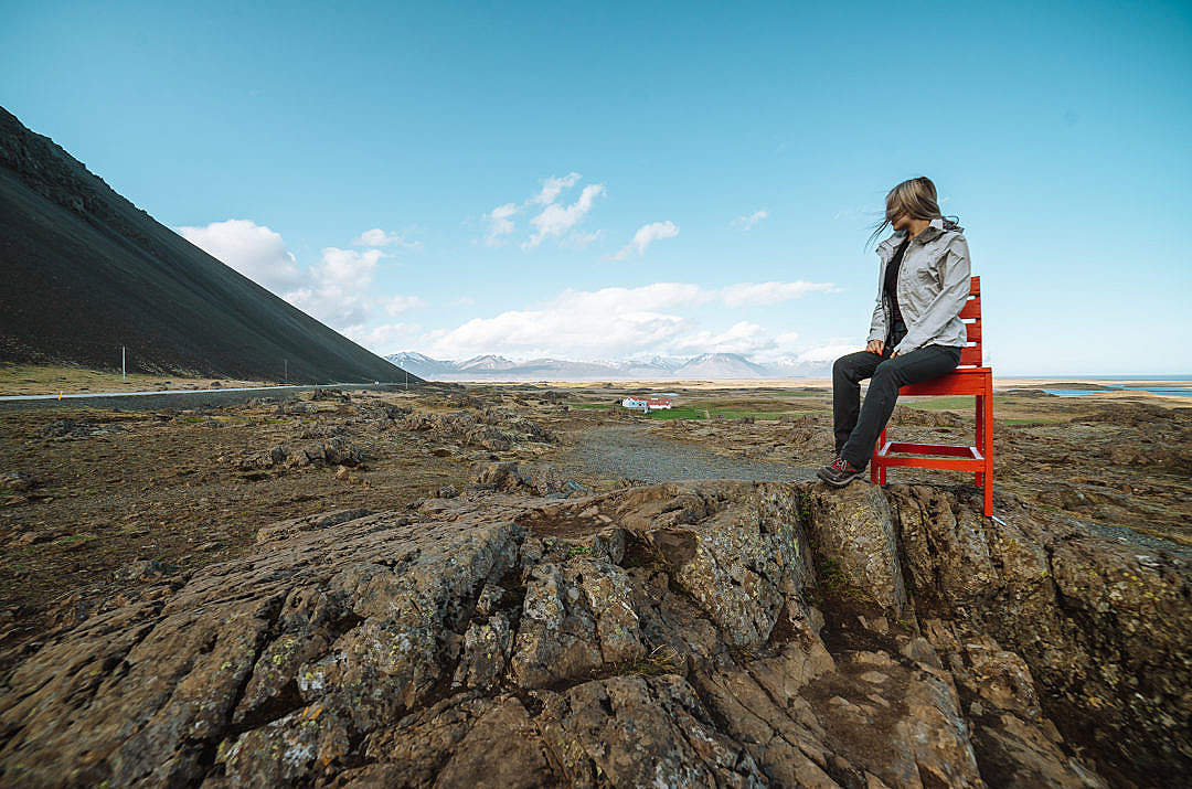 Woman Sitting on a Big Red Chair in Iceland