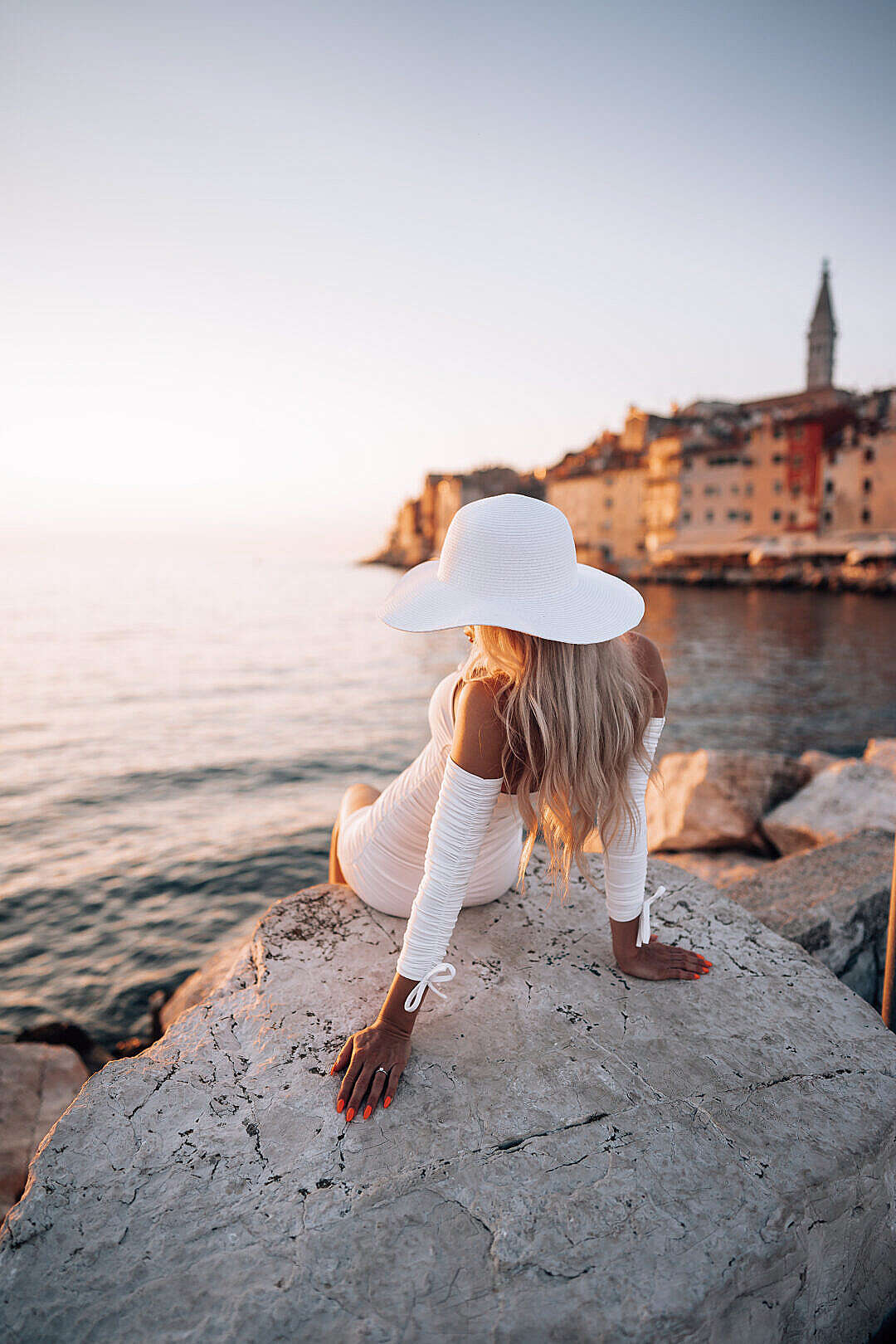 Woman Sitting on a Rock Shore Watching the Sunset in Rovinj