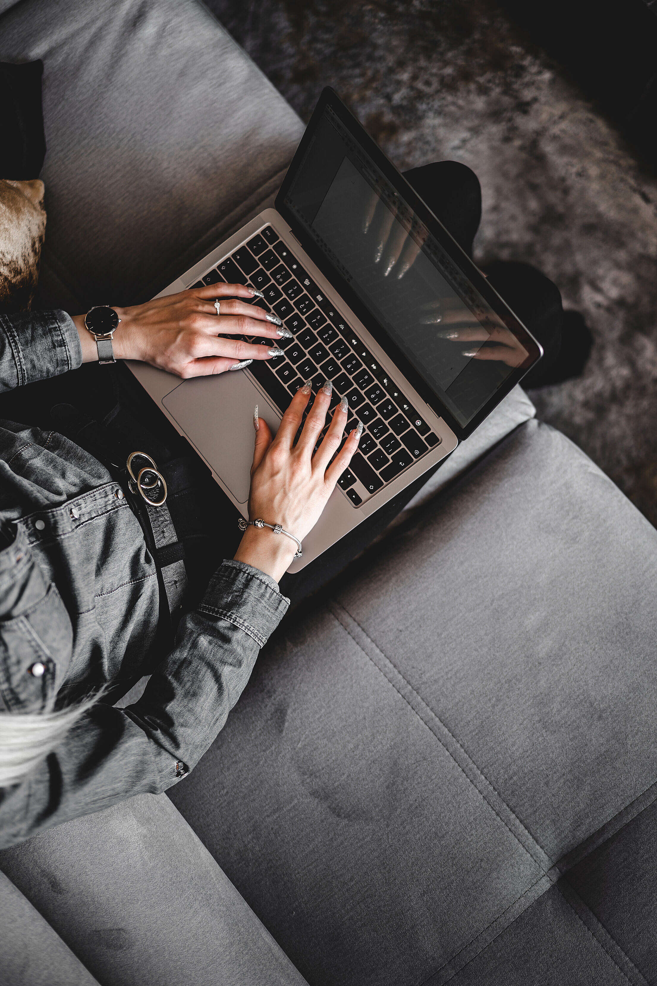 Woman Typing on Her Laptop on a Sofa Free Stock Photo
