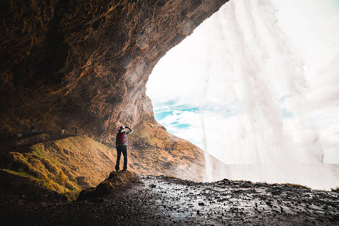 Download Woman Under Seljalandsfoss Waterfall, Iceland FREE Stock Photo
