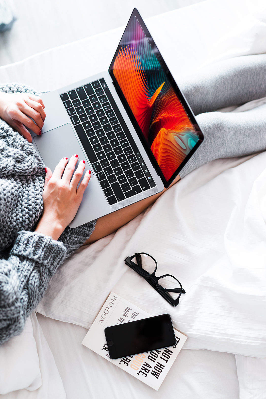 Woman Using Her New MacBook in Bed