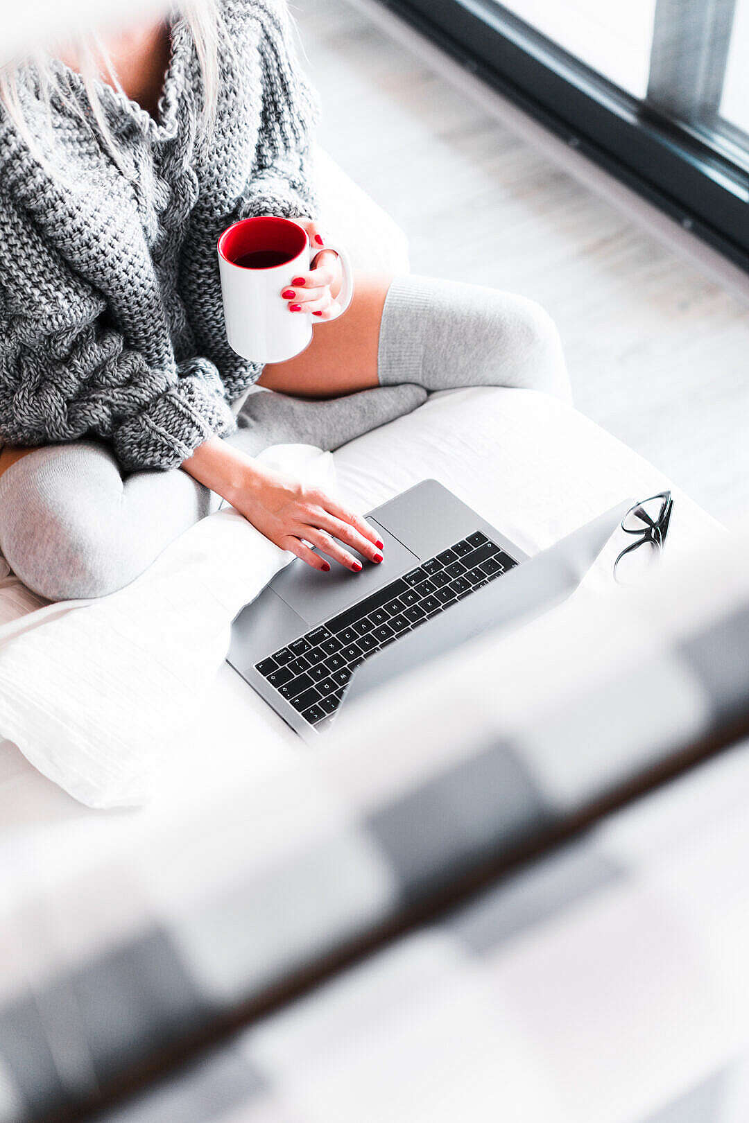 Woman Working from Her Bed with Laptop