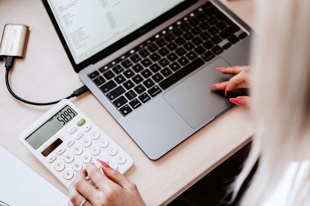 Woman Working on a Laptop and Calculator