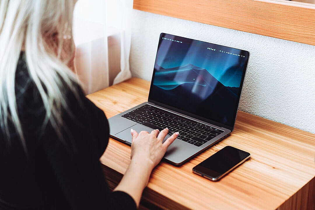 Woman Working on Modern Laptop and Smartphone