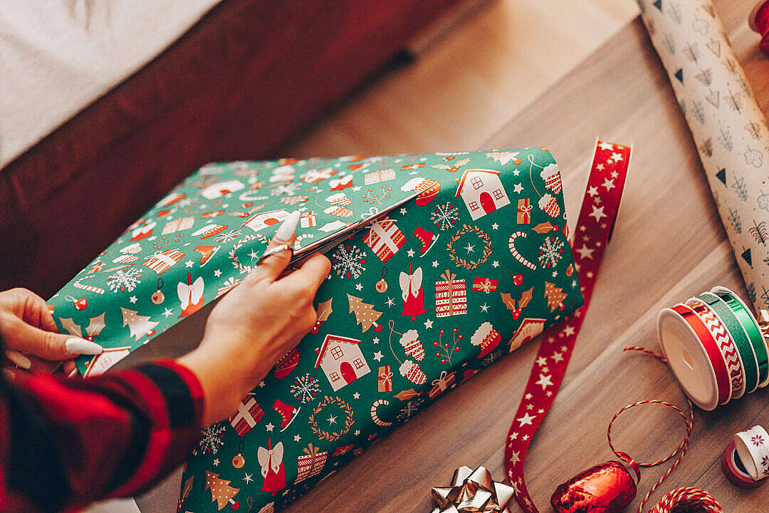 Woman Wrapping a Gift in Christmas Paper