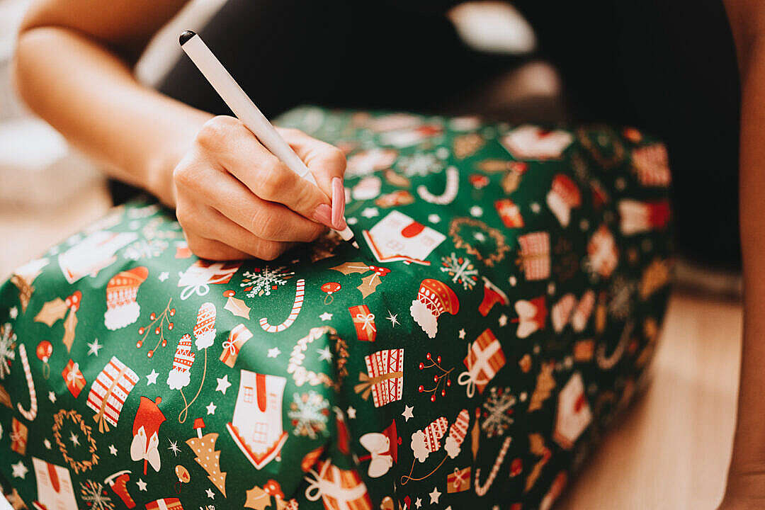 Woman Writing a Name on a Christmas Present