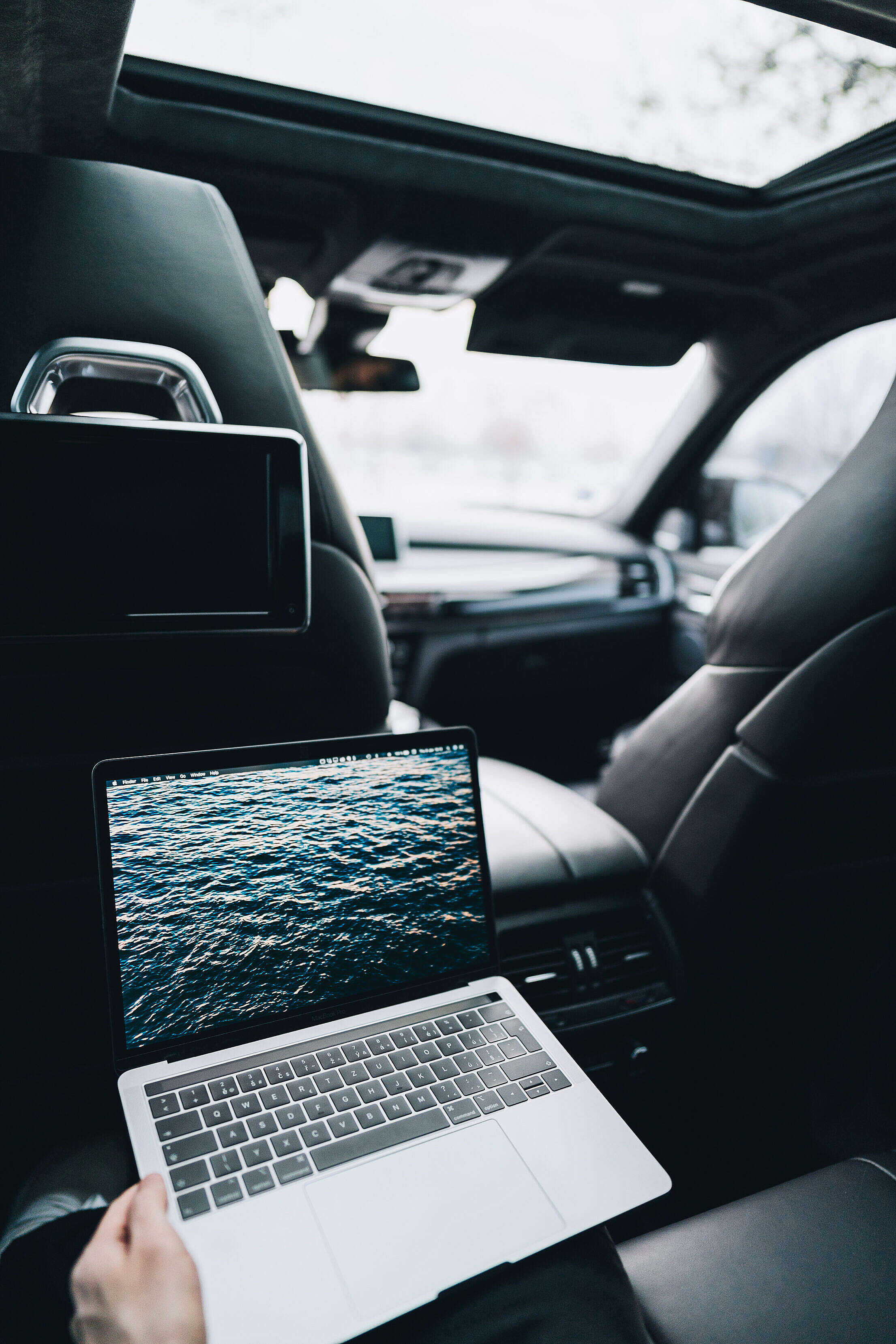 Working on a MacBook on Rear Seats in a Car Free Stock Photo