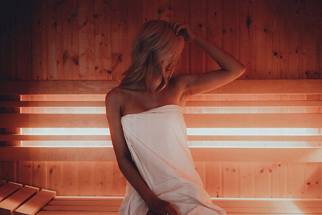 Young Blonde Woman Sitting in Finnish Sauna