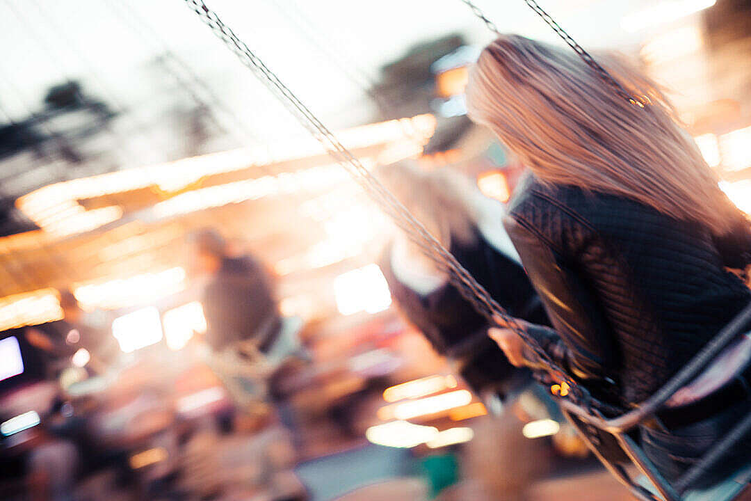 Young Girl Enjoying Crazy Ride on Swing Carousel