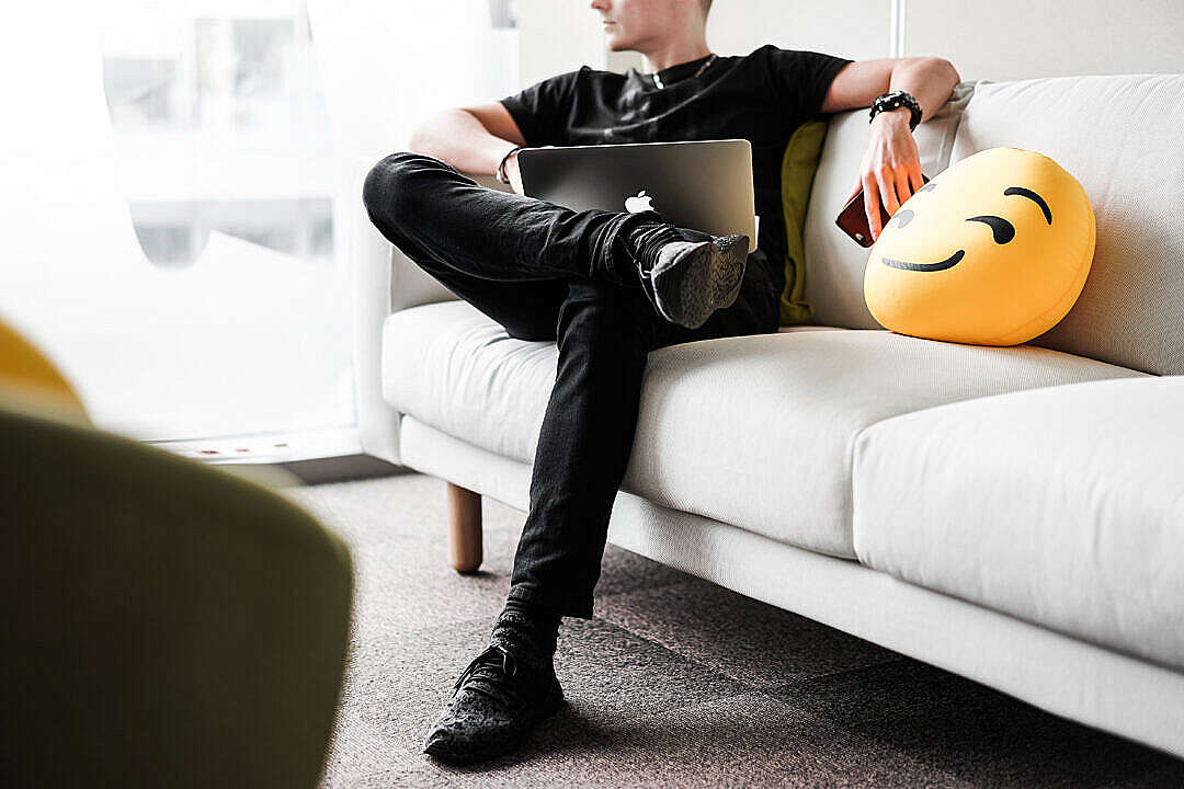 Young Man Thinking and Working with Laptop in Office Space