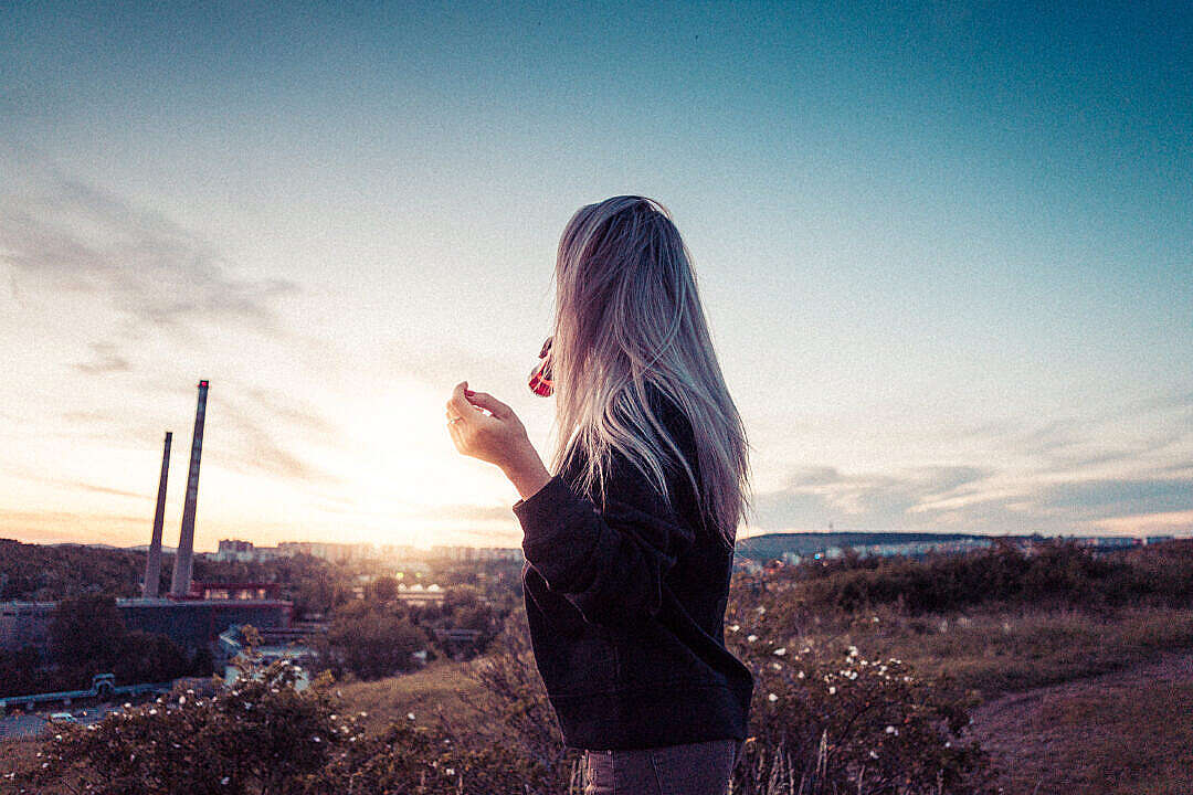 Young Millennial Girl Drinking Lemonade and Overlooking the City