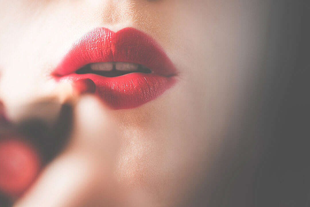 Download Young & Pretty Woman Applying Red Lipstick on Lips FREE Stock Photo