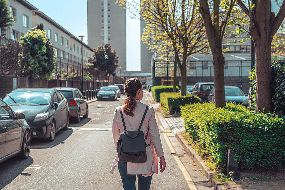 Young Solo Traveler Woman Walks Down a Street