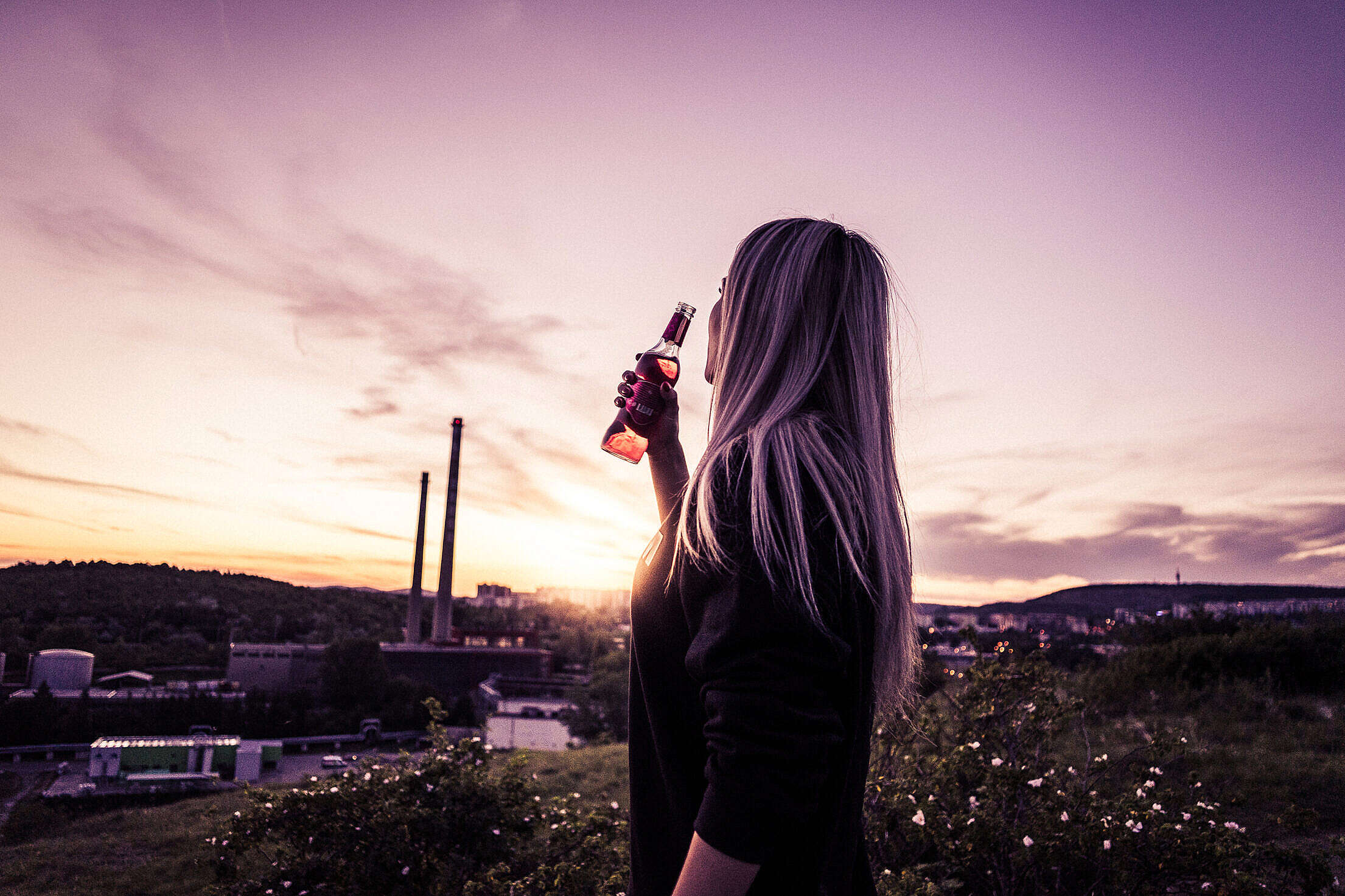Young Woman Enjoying a Drink in Sunset Free Stock Photo