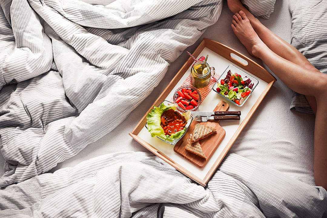 Young Woman Enjoying Morning Breakfast in Bed