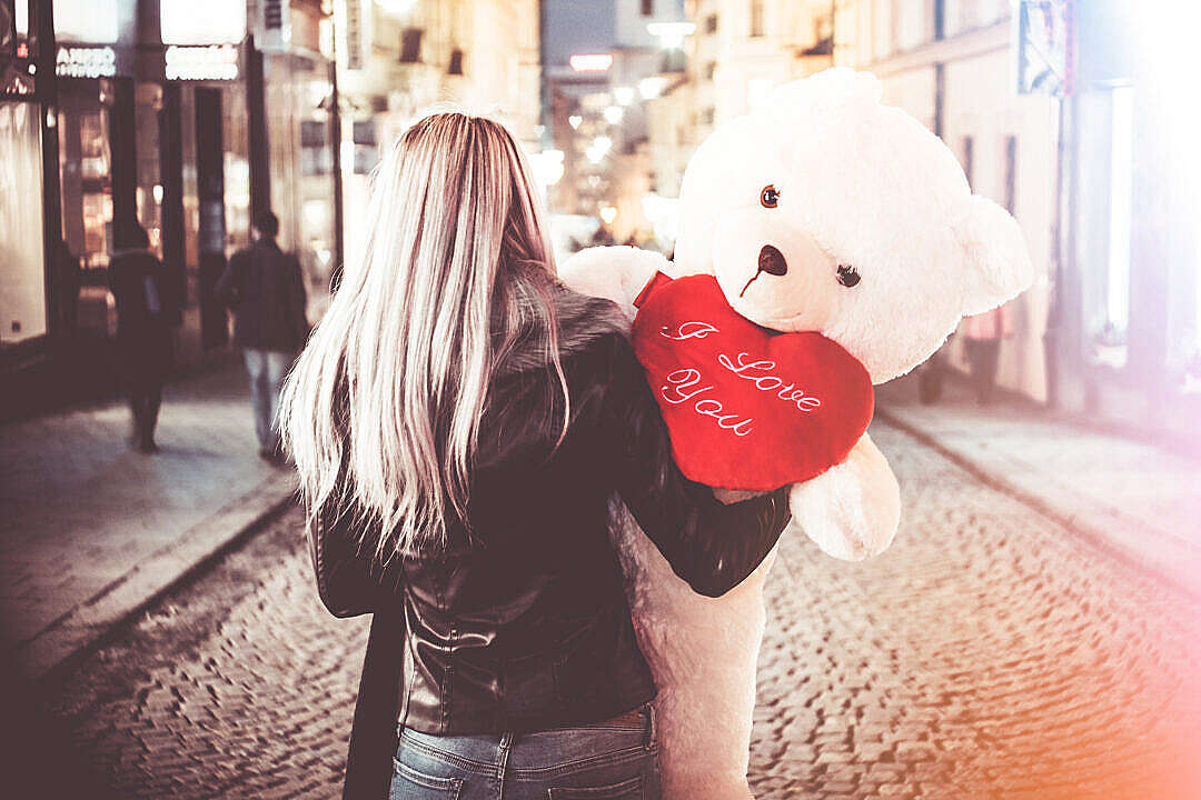 Download Young Woman Holding Her Big Valentine’s Day Gift Teddy Bear FREE Stock Photo
