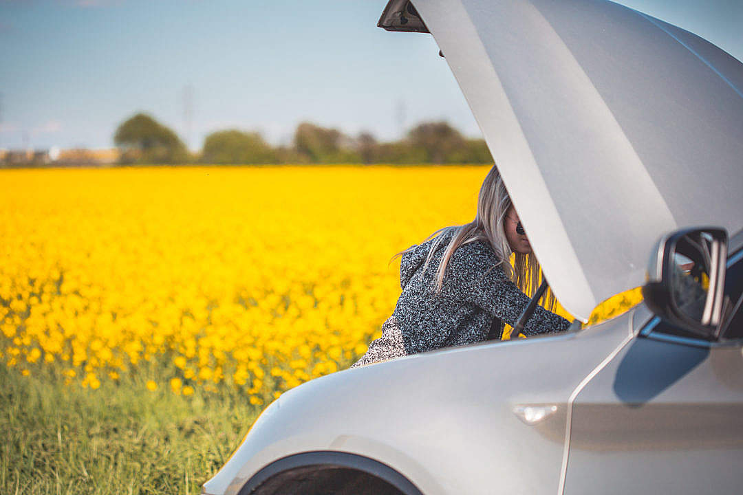 Young Woman Trying to Check and Repair Her Broken Car