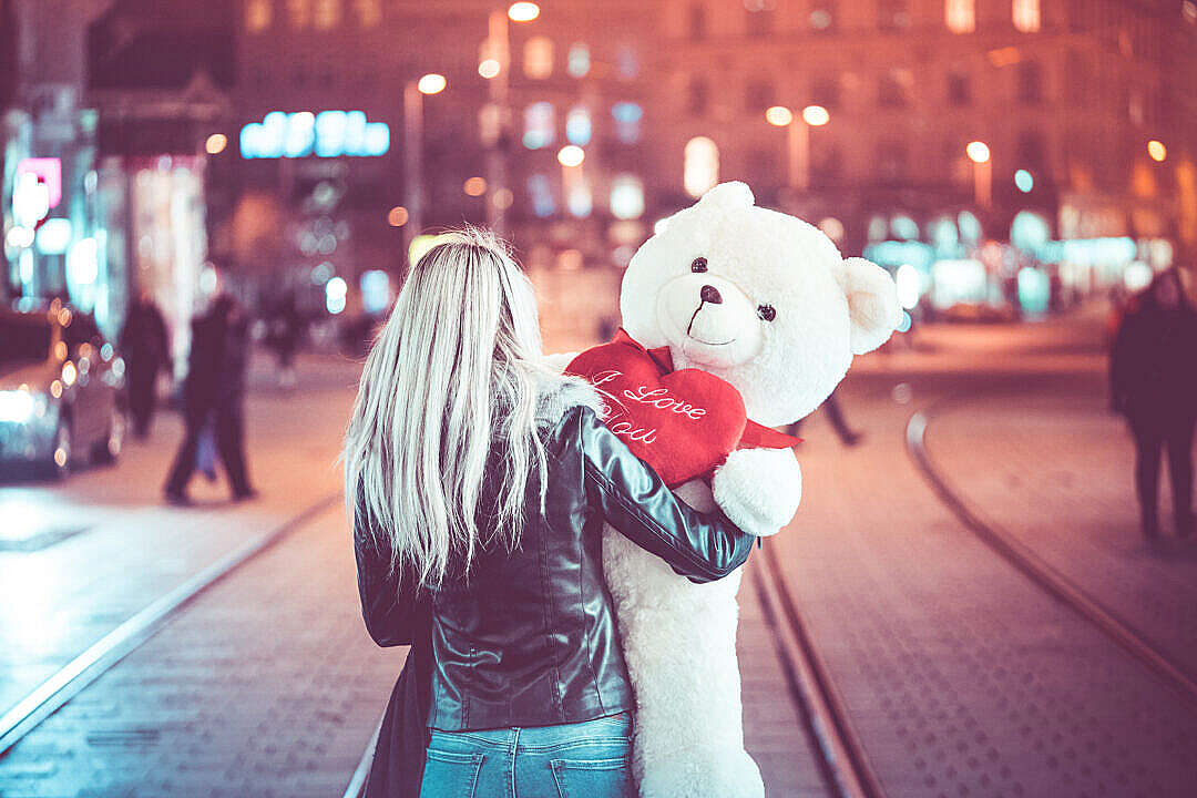 Download Young Woman Walking with a Big Teddy Bear at Night FREE Stock Photo