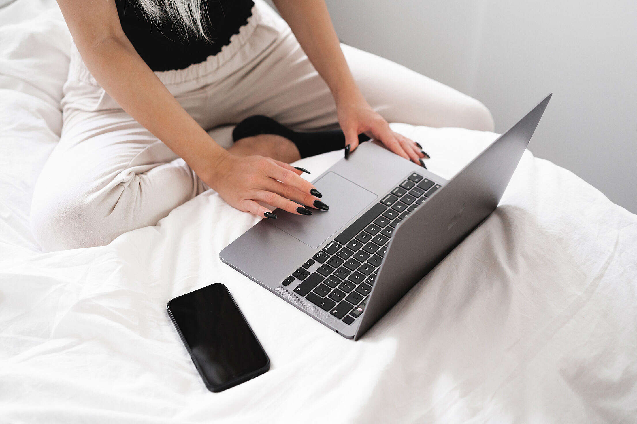 Young Woman Working on a Laptop in Bed Free Stock Photo